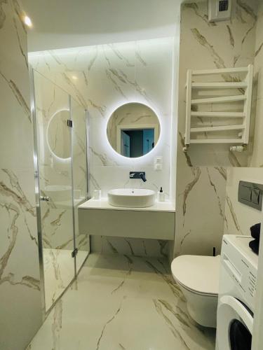 a bathroom with a sink and a mirror at Apartamenty Plaza Tower in Kielce