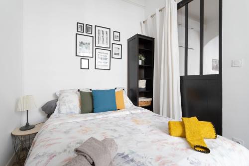 a bedroom with a large bed with colorful pillows at Cosy T2 Côté du Vieux Port & Mucem - central in Marseille