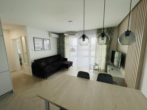 een woonkamer met een tafel en een bank bij Apartamenty Plaza Tower in Kielce