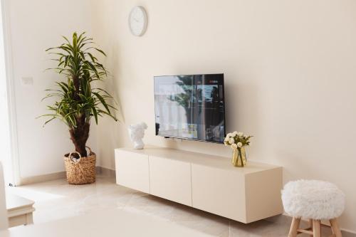 a living room with a tv on a white cabinet at CAPTAIN'S RESIDENCE in Ksamil
