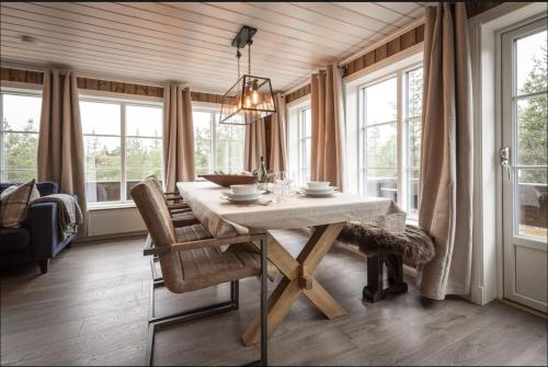 a dining room with a table and some windows at Cabin with sauna in Trysil in Trysil