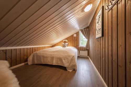 een slaapkamer met een bed in een houten hut bij Cabin with sauna in Trysil in Trysil