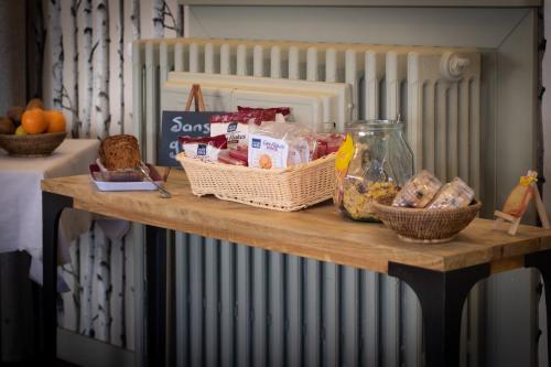 Una mesa con pan y otros alimentos sobre ella. en Logis Hôtel Tante Yvonne & son restaurant semi-gastronomique - Lyon Nord, en Quincieux