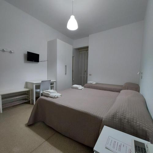 a bedroom with a bed and a desk and a television at Hotel Villa Alberta B&B in Cesenatico