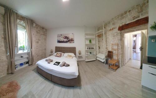 a bedroom with a large bed in a room at Studios Kadena Trogir - 18th century stone house in Trogir