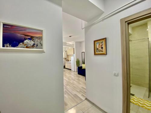 un pasillo con paredes blancas y una pintura en la pared en Vedere la mare apartament, en Mamaia