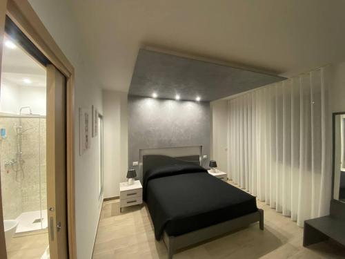 um quarto com uma cama preta e uma casa de banho em Casa del Monte em Enna