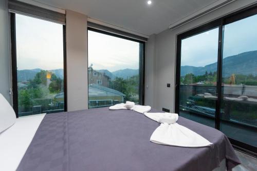 a bedroom with a large bed with large windows at Diamond Port Gocek in Göcek