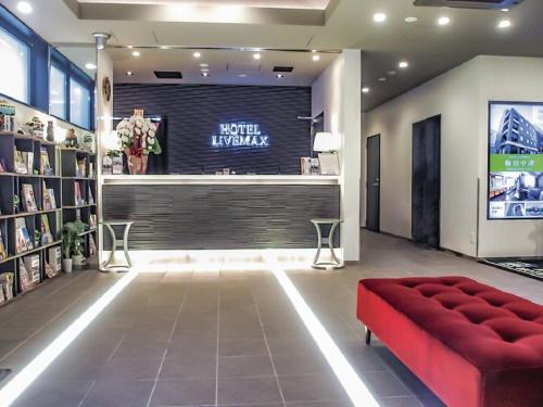 a lobby with a red couch in a store at HOTEL LiVEMAX Fukuyama Ekimae in Fukuyama