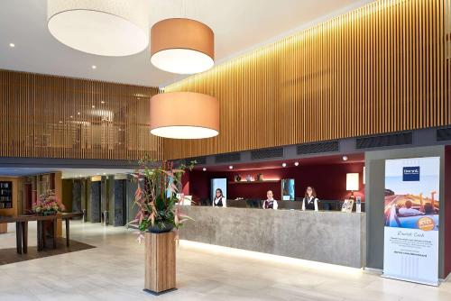 eine Lobby mit einer Rezeption und einem Restaurant in der Unterkunft Dorint Kongresshotel Mannheim in Mannheim