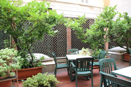 a patio area with a table, chairs, and plants at Sant'Ambroeus in Milan