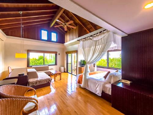 a bedroom with a bed and a living room at LiVEMAX Amms Hotels Canna Resort Villa in Ginoza