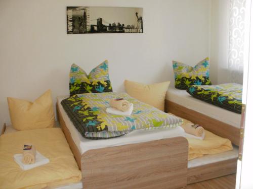 ツヴェンカウにあるFerienwohnung Zieroldのベッド2台と枕付きのベッド1台が備わる客室です。