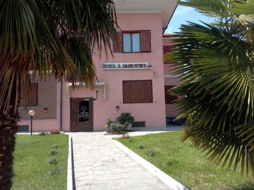 a pink building with a palm tree in front of it at fell hotel in Susa