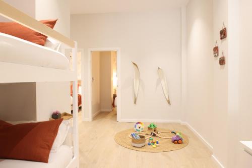 Habitación con litera y mesa con juguetes en el suelo en FLORIT FLATS - The Serreria Rooms, en Valencia