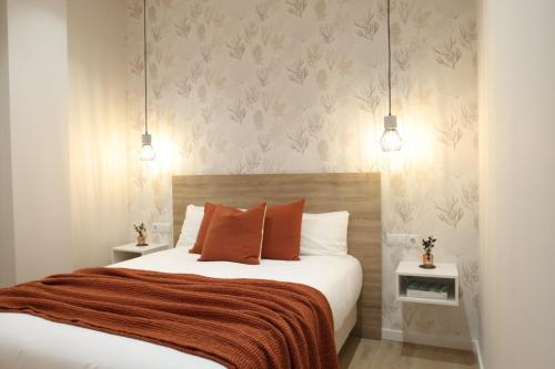 a bedroom with a large bed with orange pillows at CASA FLORIT - The Maritim Serreria Suites in Valencia
