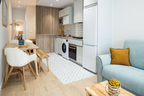 a kitchen and living room with a couch and a table at CASA FLORIT - The Maritim Serreria Suites in Valencia