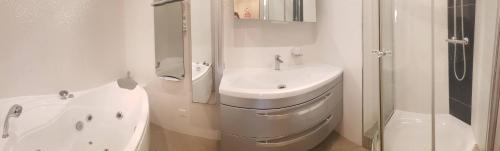 une salle de bain blanche avec un lavabo et une douche dans l'établissement Elégant T3 avec Spa, à Ajaccio