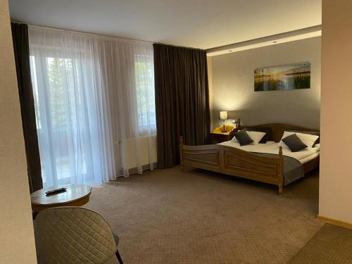 a hotel room with a bed and a window at Hotel Baltazar Pułtusk in Pultusk