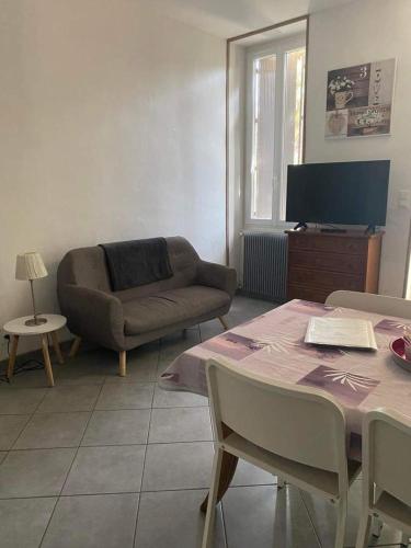 a living room with a couch and a table at Les Palmiers in Millau