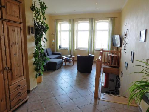 a living room with a couch and some plants at Seelotsenstation Sassnitz mit Hafenblick by Unsere Urlaubszeit in Sassnitz