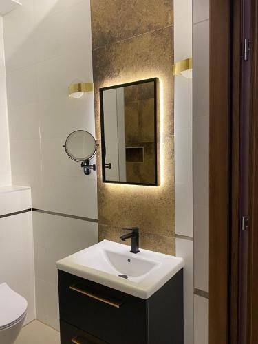 a bathroom with a sink and a mirror at Hotel Baltazar Pułtusk in Pułtusk