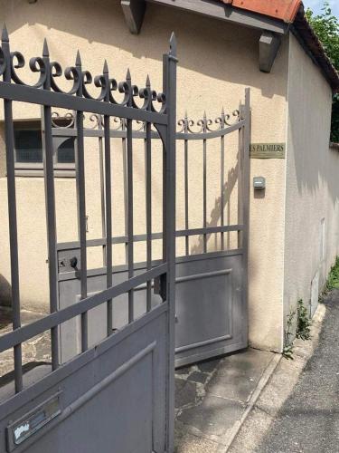 a gate to a house with an open door at Les Palmiers in Millau