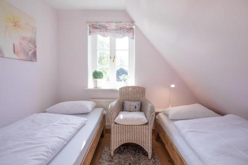 Cette chambre dispose de deux lits, d'une chaise et d'une fenêtre. dans l'établissement Reethüs Brodersen, à Risum-Lindholm