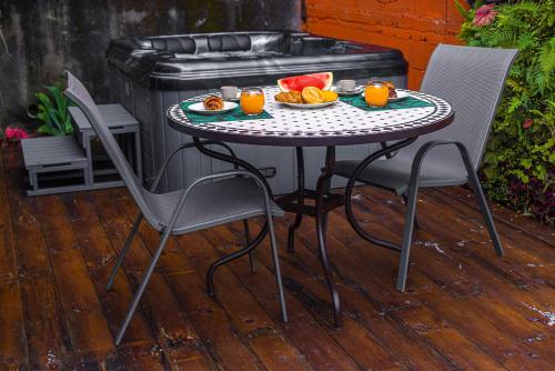 a table with a plate of fruit and orange juice at JASMIN DE NUIT - Villa FOURNAISE in Le Tampon