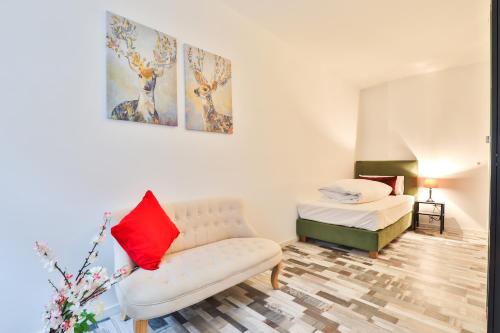 ein Wohnzimmer mit einer Couch und einem Bett in der Unterkunft Hotel JUMAs in Bad Zwischenahn