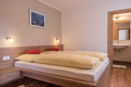 ein Schlafzimmer mit einem großen Bett und einem Waschbecken in der Unterkunft Hilber App Fermeda in Villnöß