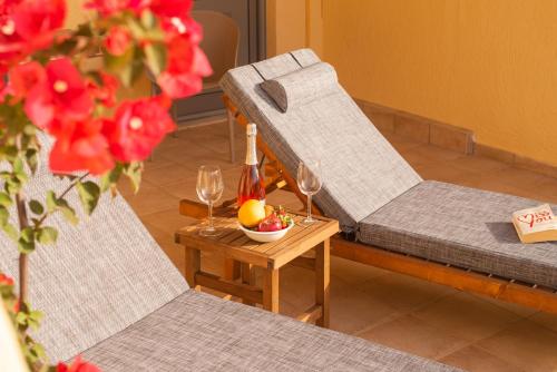 a room with two chairs and a table with wine glasses at Elounda Heights (Adults Only) in Elounda