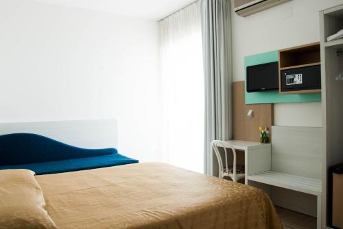 a bedroom with a bed and a tv on a wall at Hotel Eden in Grottammare