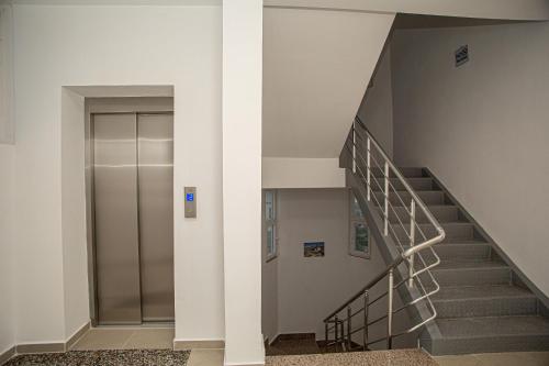 a staircase in a building with a metal elevator at Hotel SUNSET GL in Vlorë