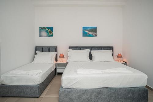 two twin beds in a room with two lamps at Hotel SUNSET GL in Vlorë