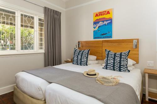 a hotel room with a bed with a hat on it at Camps Bay Village - Stone Cottages in Cape Town