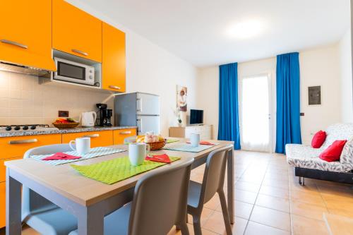 a kitchen and dining room with a table and chairs at Pini Village Lido Altanea in Caorle