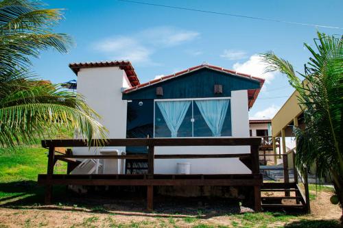 uma casa azul e branca com um banco à frente em Pousada Bugaendrus em Touros