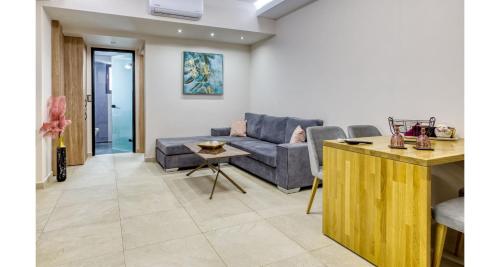 a living room with a couch and a table at Sapphire Blue Suites in Kissamos