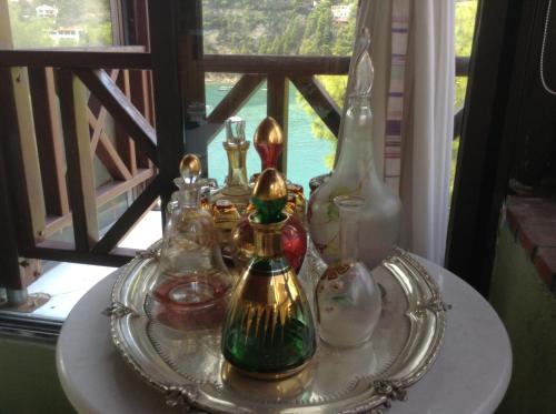 a tray of glass bottles on a table with a window at Liadromia Hotel in Patitiri