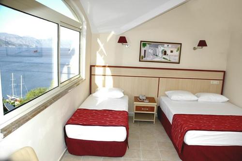 מיטה או מיטות בחדר ב-MERİÇ HOTEL TURUNÇ