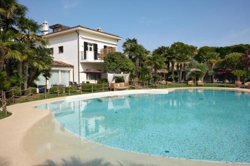 a large swimming pool in front of a house at Villa Carlotta Jesolo Lido in Lido di Jesolo
