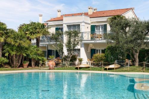 une grande piscine en face d'une maison dans l'établissement Villa Carlotta Jesolo Lido, à Lido di Jesolo