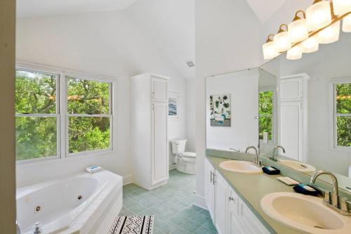 a bathroom with two sinks and a tub and a toilet at 307 W Indian - The Prickly Pear in Folly Beach