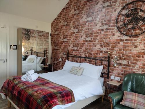 a bedroom with a bed and a brick wall at Dunseverick Ramblers Rest in Bushmills