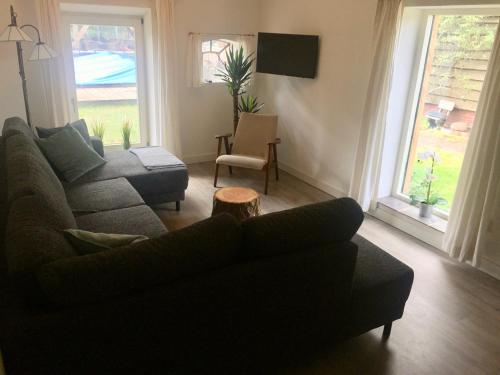 uma sala de estar com um sofá e uma cadeira em vakantiewoning Bovenhaar em Punthorst