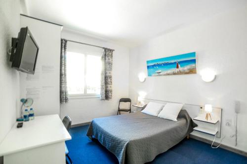 a hotel room with a bed and a tv at Le Fanal in Argelès-sur-Mer