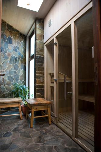 a glass door in a room with a bench and a table at Cuarzo Lodge in Pichilemu