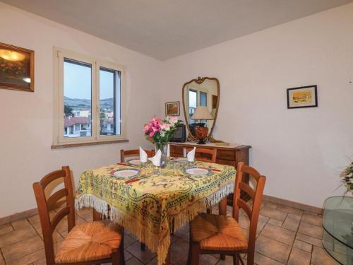 een eetkamer met een tafel met stoelen en een spiegel bij Villa La Ciaccia in Valledoria