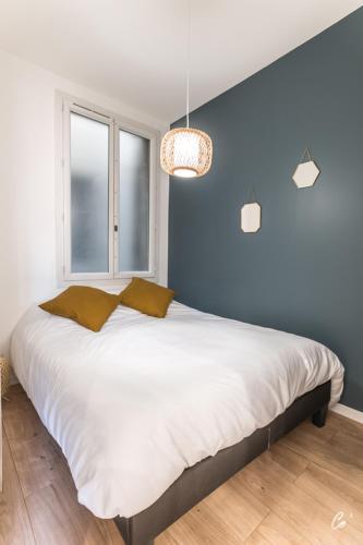 une chambre avec un grand lit avec un mur bleu dans l'établissement COSY COMEDIE, à Bourg-en-Bresse